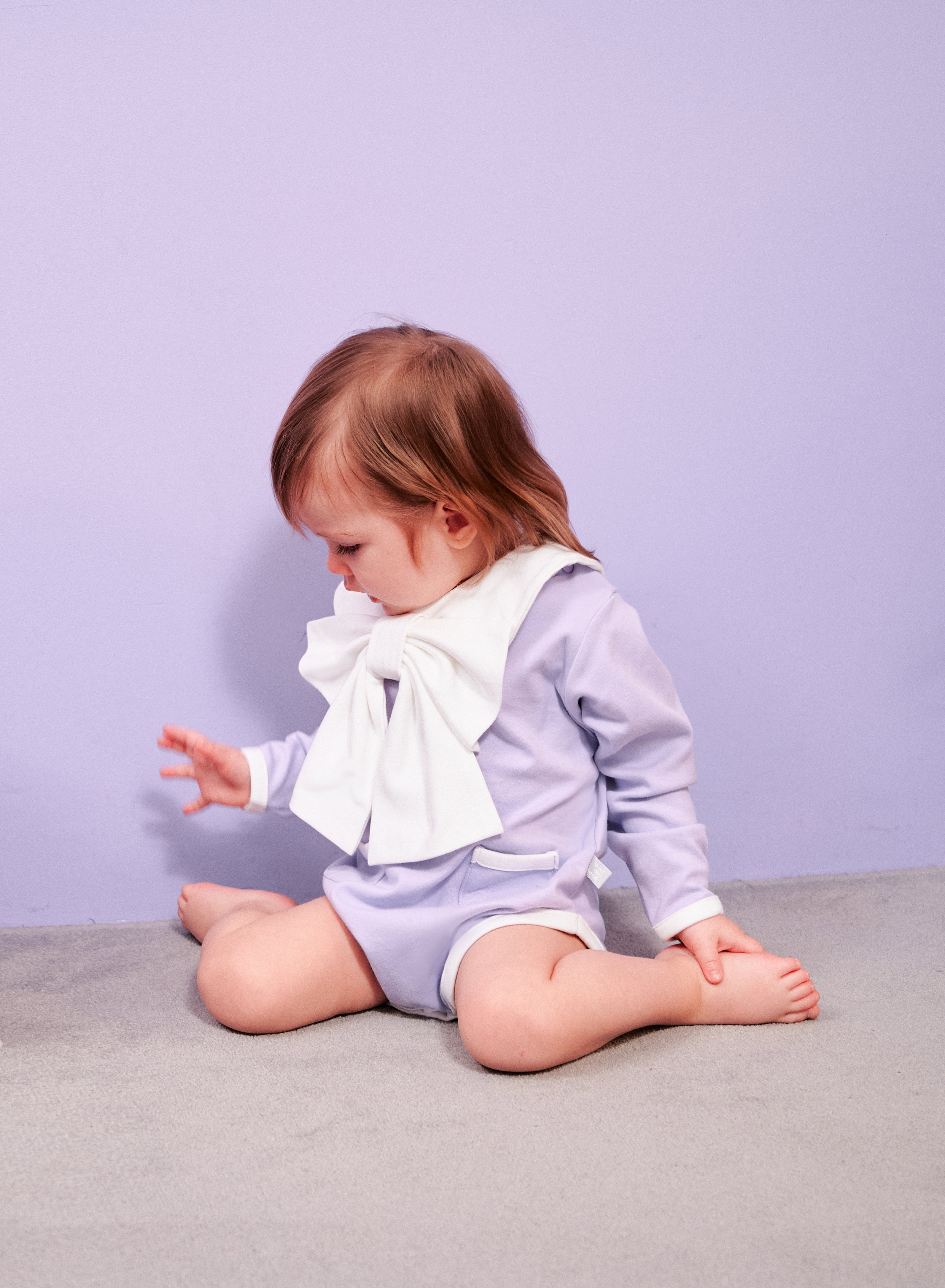 Dress Up Bodysuit Long Sleeve + Pants SET (Lavender): Minimalistic design with contrasting lines, ribbon scarf bib, and adorable pocket details.