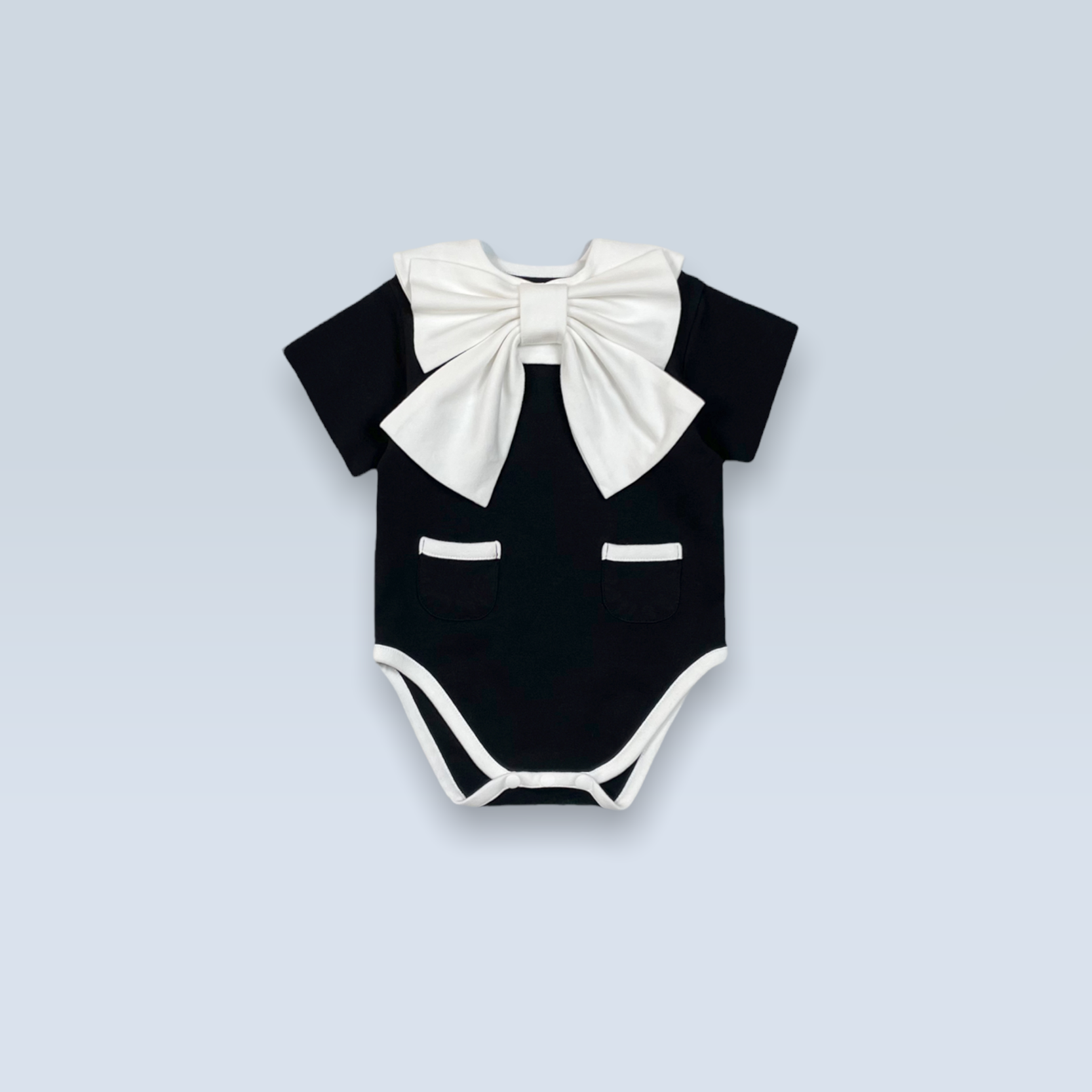 Dress Up Bodysuit (Black): Minimalistic design with contrasting lines and charming pocket details. Paired with a ribbon scarf bib for a formal look.